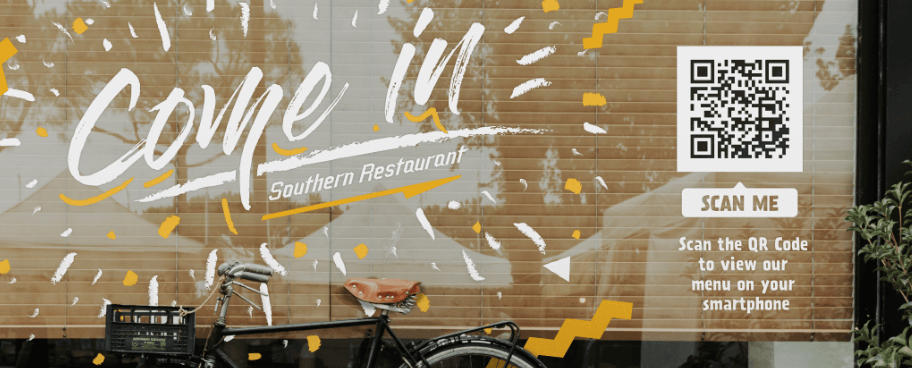 QR Code auf einem Restaurant-Fenster, der Vorbeigehende zum Scannen auffordert, um einen Blick auf die Speisekarte zu werfen.