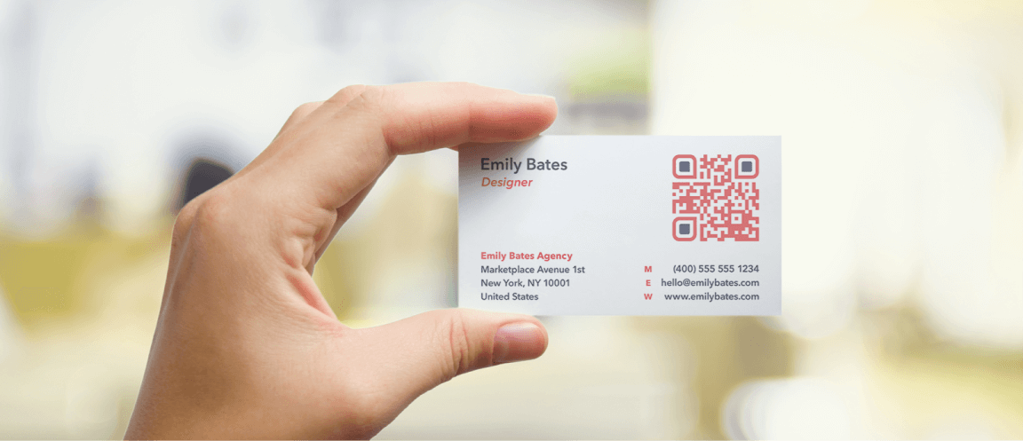 Eine Hand hält eine Visitenkarte mit aufgedrucktem QR Code in Rot und Schwarz.