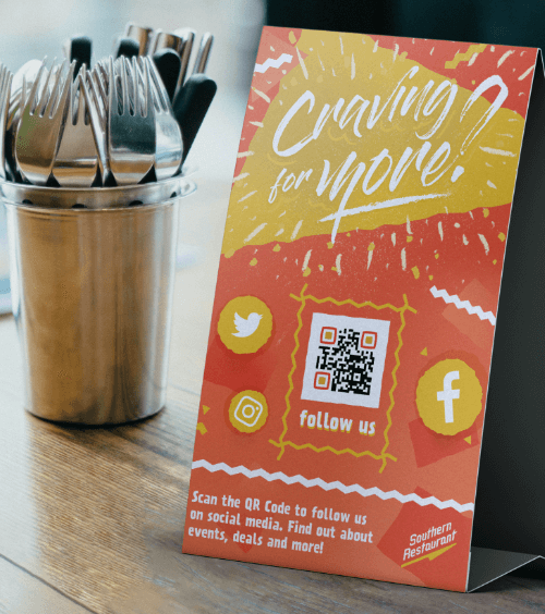 Tischaufsteller in einem Restaurant mit einem QR Code zum Folgen seiner Social-Media-Auftritte.