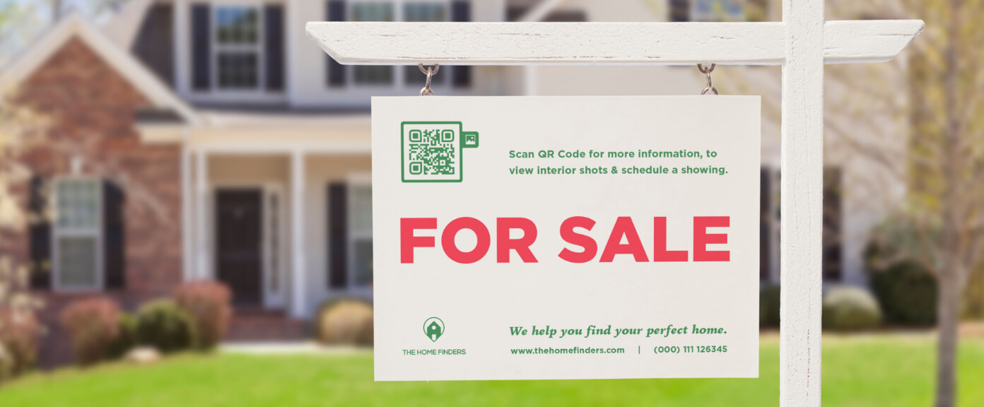 „Zu verkaufen“-Schild vor einem Haus mit einem QR Code, der Bilder der Innenausstattung in einer Galerie anzeigt.