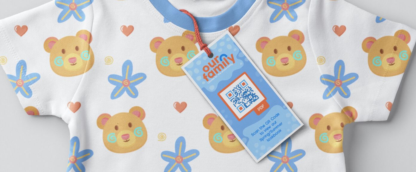 Hängeetikett an Babykleidung mit einem QR Code, der die aktuelle Kollektion im PDF-Format anzeigt.