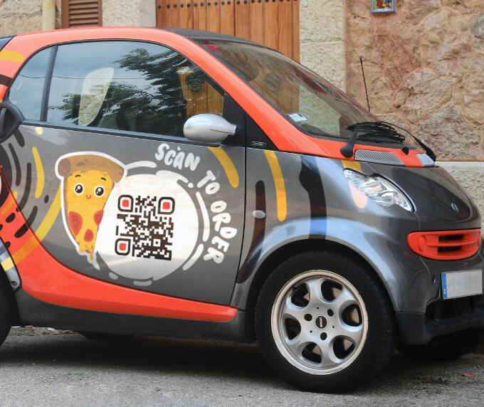 Lieferservice-Fahrzeug mit einem QR Code, der die entsprechende Bestell-Seite verlinkt.