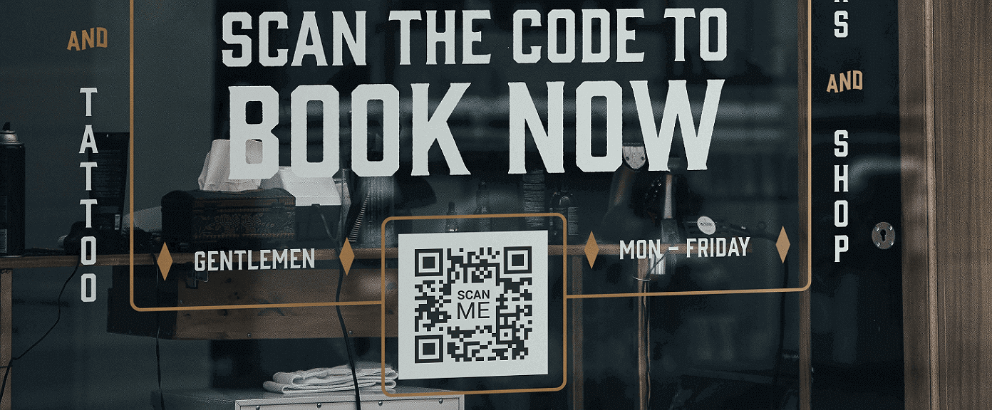 A tattoo shop window with a QR Code that lets customers book an appointment directly from their smartphones.