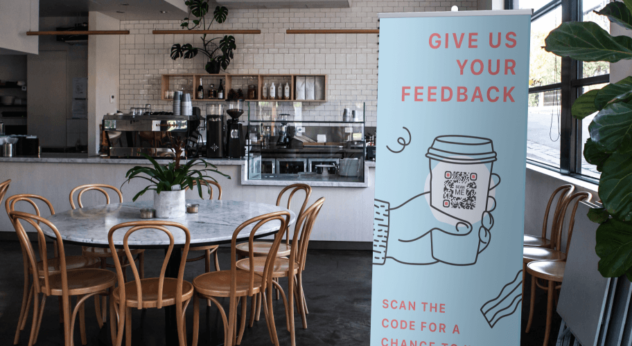 QR-Code-Werbung in einem Café, die Gäste zum Abgeben von Feedback auffordert.